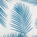 A close up view of a rectangular teal outdoor cushion with beautiful palm leaf pattern on both sides.