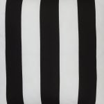 A close up view of black and white outdoor floor cushion is shown with stripes on one side and a solid colour on the other.