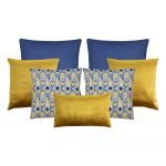 An image of seven cushion covers featuring two blue cushions, three gold cushions and two blue and yellow cushions with a chevron pattern