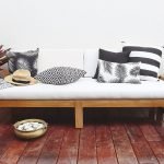 Black and white outdoor cushions on a white three seater outdoor lounge