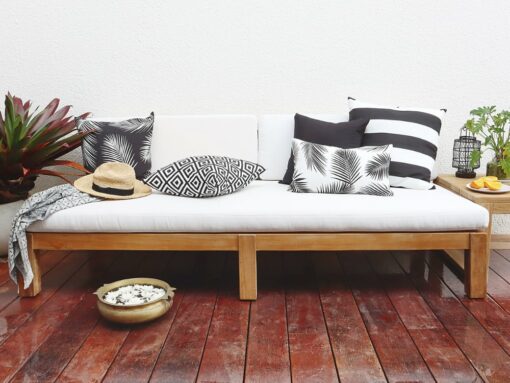 Black and white outdoor cushions on a white three seater outdoor lounge