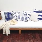 Navy outdoor cushions covers with some beige cushions and a gorgeous beige throw rug on an outdoor setting