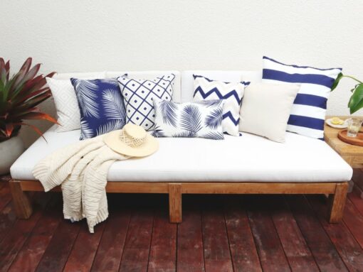 Navy outdoor cushions covers with some beige cushions and a gorgeous beige throw rug on an outdoor setting