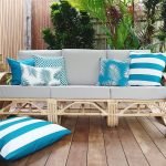 Teal outdoor cushion covers sitting on an outdoor lounge with a teal outdoor cushion cover on the floor