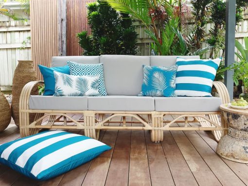 Teal outdoor cushion covers sitting on an outdoor lounge with a teal outdoor cushion cover on the floor
