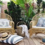 Grey outdoor cushions sitting on wicker chairs with a grey outdoor floor cushion