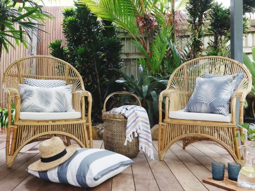 Grey outdoor cushions sitting on wicker chairs with a grey outdoor floor cushion