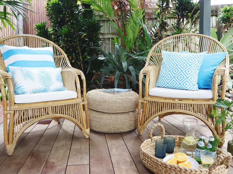 Blue and white cushions styled on an outdoor setting of two chairs and a side table