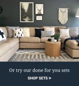 Dark grey living room with beige sofa featuring Scandi inspired black and white lounge cushions. Shop sets.