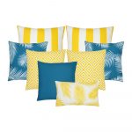 A collection of eight outdoor cushion covers in teal and yellow cushion covers in striped, plain, geometric and leaf designs.