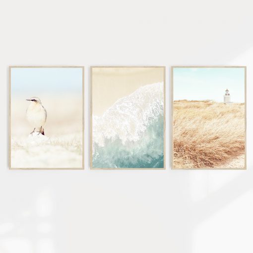 Three coastal inspired A2 wall prints in blue and sandy brown hues with images of a lighthouse, beach and a bird