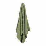 An image of a knitted throw blanket in sage green colour