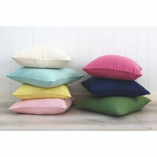 Stack of bright colourful cushions against a wall