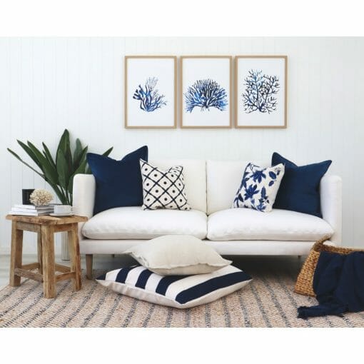 Set of Hamptons style cushions on a white sofa with a striped floor cushion and Hamptons wall art