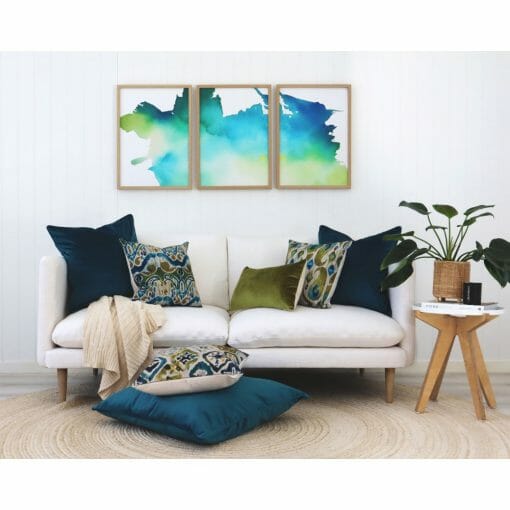 Ikat cushions in olive and teal on a white sofa with floor cushions and Ikat wall art