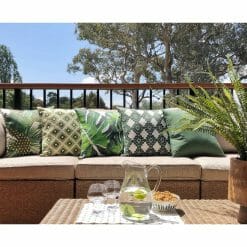 Various jungle inspired green outdoor cushions in light brown sofa