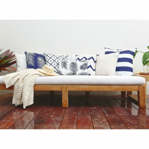 Navy outdoor cushions in stripe, chevron, diamond and floral patterns on top of white wooden daybed.