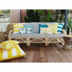 Teal and yellow striped, diamond and floral patterned outdoor cushions in grey rattan sofa