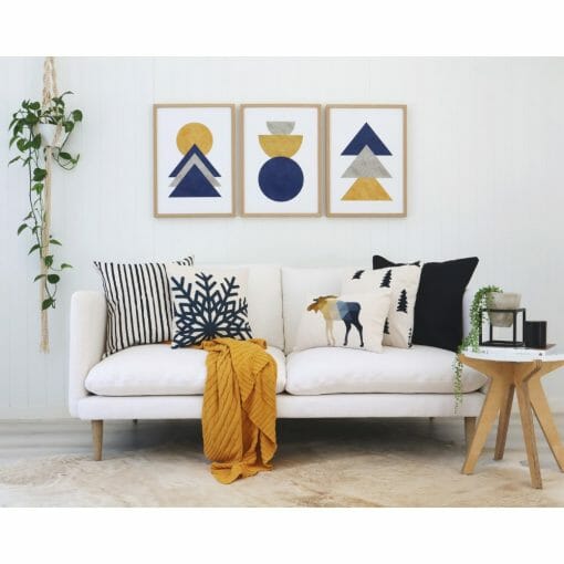 Scandi style cushions with a mustard throw on a white sofa with Scandi wall art
