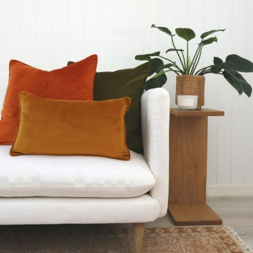 Gold, terracotta and olive velvet cushions on a white sofa