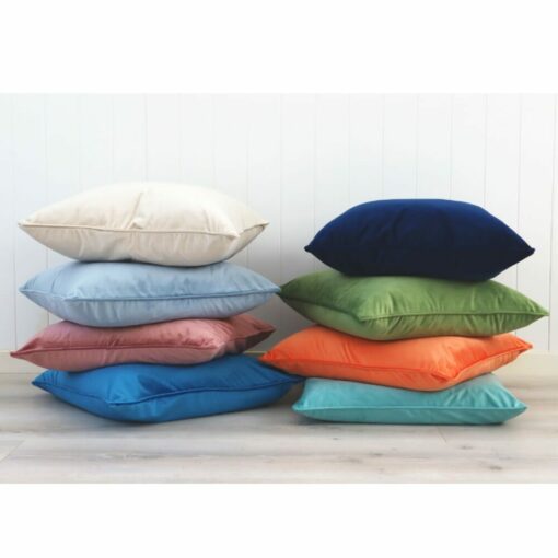 Two stacks of bold velvet cushions abasing a white wall