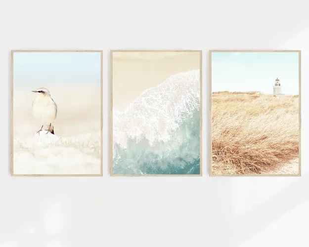 Three coastal wall art prints on a wall featuring Australian beach scenes.
