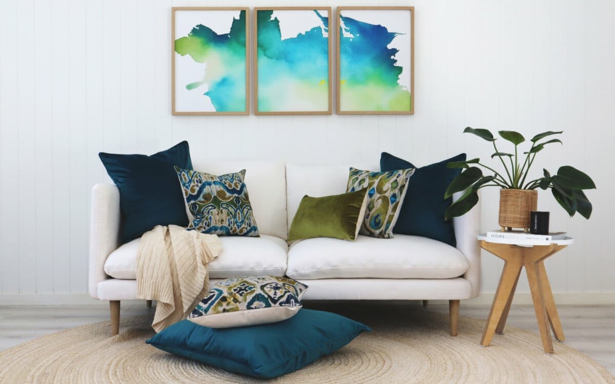 Ikat Cushions in rich blue and greens styled on a white sofa with abstract art in the background