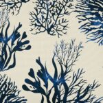 Close up of Hamptons blue and white cushion with coral print