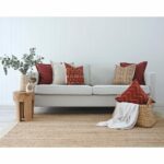 Neutral-coloured living room with clay-coloured cushions in tribal prints