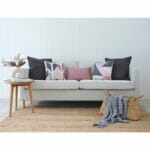 Neutral-coloured sofa with pink and grey cushion covers with triangle prints