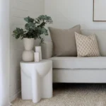 A set of 4 designer cushions have been styled on a grey sofa in a white painted living room.