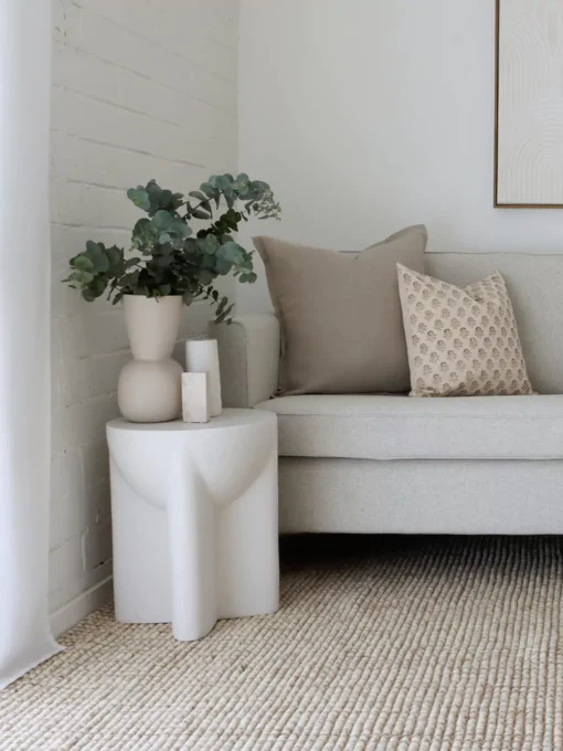 A set of 4 designer cushions have been styled on a grey sofa in a white painted living room.