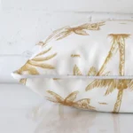Mustard palm tree cushion cover laid on its back side. The image shows a side-on view of the outdoor material and its square dimensions.