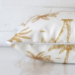 Mustard palm tree cushion cover laid on its back side. The image shows a side-on view of the outdoor material and its square dimensions.