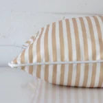 A side view of beige striped cushion that has outdoor fabric and a square size.