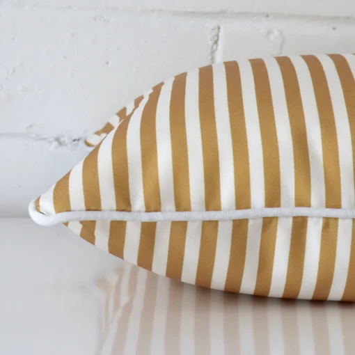 Side angle shot of outdoor square cushion cover. The mustard hue and striped style are shown along its seams.
