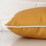 A side view of mustard cushion that has an outdoor fabric and has a rectangle size.