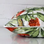 Side perspective showing seam of square cushion cover that has a parrot tropical motif on its outdoor fabric.