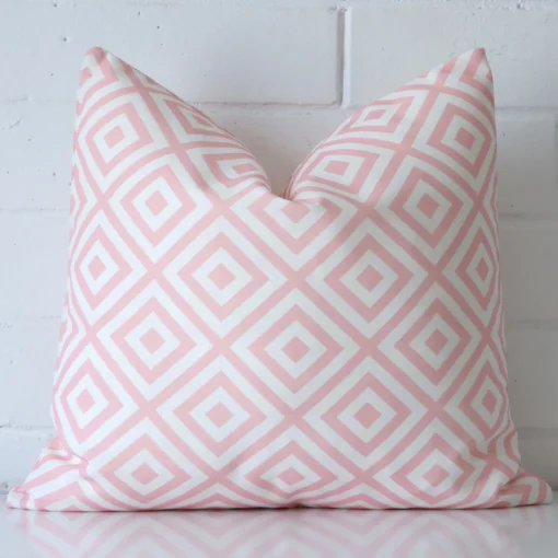 An eye-catching outdoor square cushion cover featuring a hue that is pink. It has a unique geometric style.