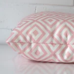 Outdoor pink cushion laying on its side. The geometric design and its square size are visible.