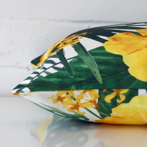 Yellow tropical cushion cover laid on its back side. The image shows a side-on view of the outdoor material and its square dimensions.