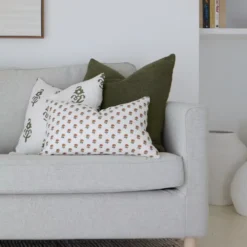 A lovely arrangement of sofa cushions in a corner of a light grey sofa.