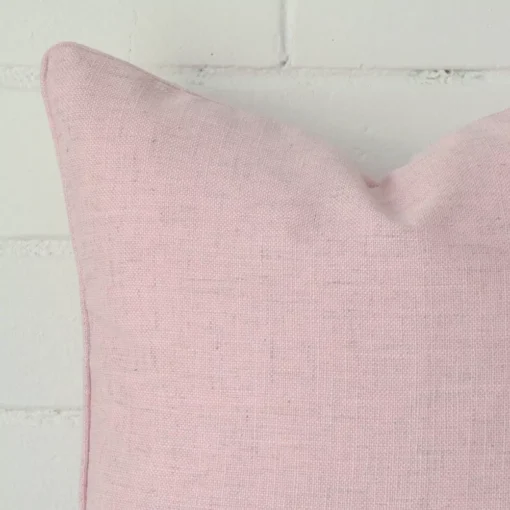 Magnified view of this linen pink cushion cover’s corner. It has a square size.