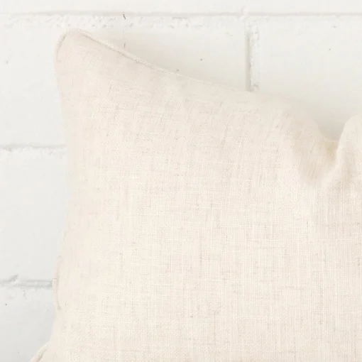 Macro shot showing the top left side of this rectangle linen cushion. The cream hue is magnified.