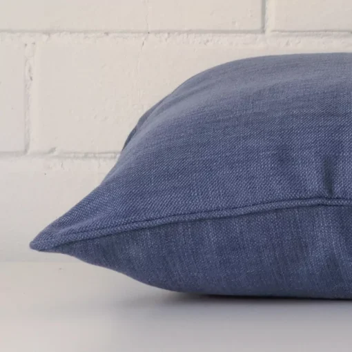 Side edge of square cushion. The linen material and blue can be seen from this lateral viewpoint.