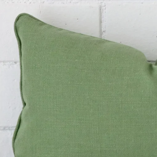 Magnified view of this linen sage green cushion cover’s corner in a rectangle size.