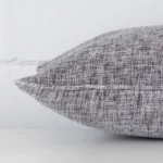 Side edge of rectangle cushion. The linen material and grey colour can be seen from this lateral viewpoint.