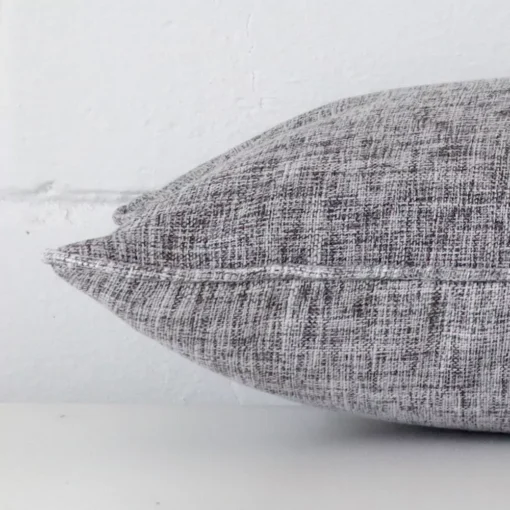 Side edge of rectangle cushion. The linen material and grey colour can be seen from this lateral viewpoint.