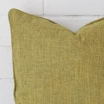 Cropped shot of top left corner of this olive cushion cover. This viewpoint shows the linen fabric and square shape with more precision.