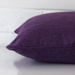 Lateral viewpoint of this linen square cushion. The TYPE design and plum purple colour is shown from the side showing the front and rear panels.